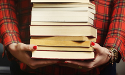 Hands holding a stack of books